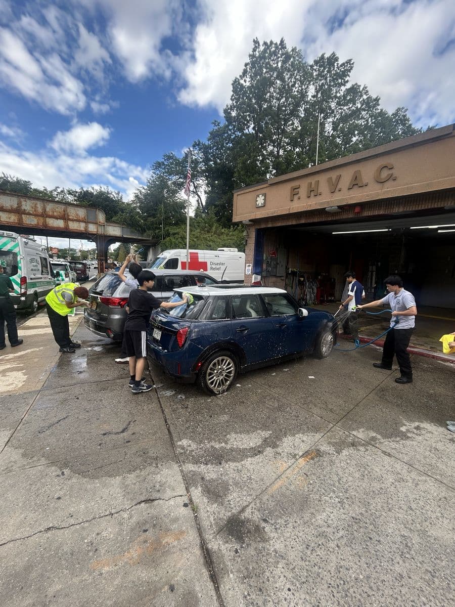 Youth Corps members washing cars in front of the FHVAC garage